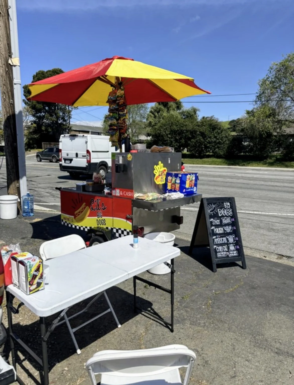 Lil’s Big Dogs mobile cart under its red and yellow umbrella