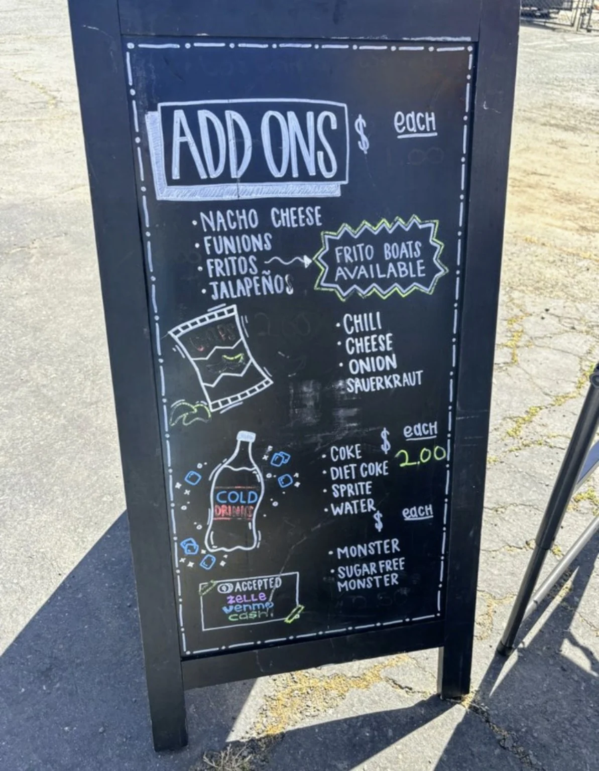 Lil's Big Dogs chalkboard showing add-ons and drinks